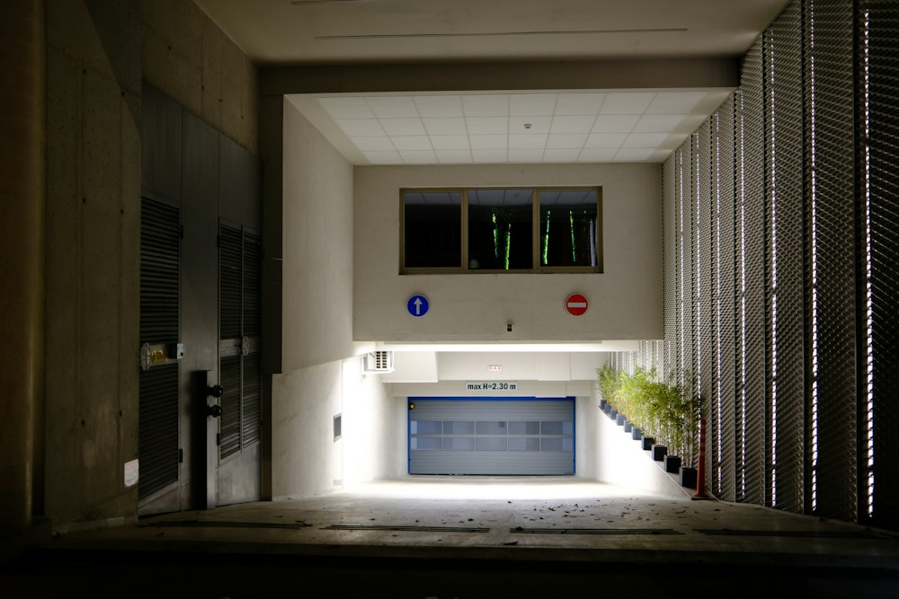 Acceso vehicular iluminado de noche, con portón automático